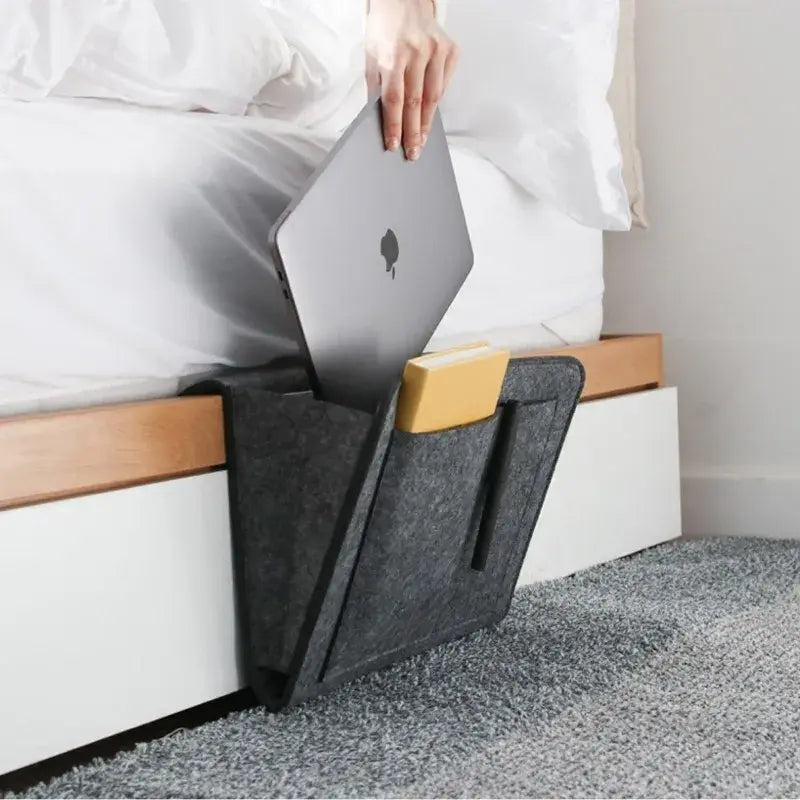 AmoorCity Felt Bedside Caddy. Felt bedside organizer with 5 pockets for storing phones, books, glasses, and other bedside essentials. Keeps items within reach while you relax in bed.